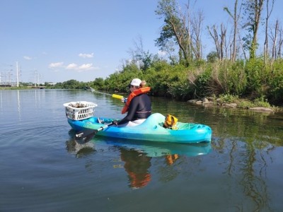 Photo of a volunteer picking up litter while in a kayak
